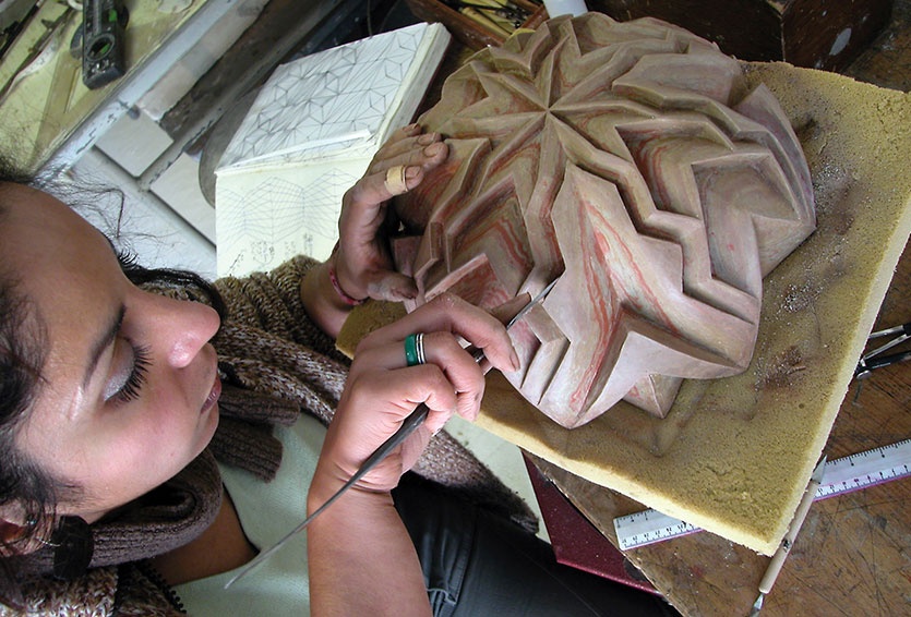 Halima carving a design 