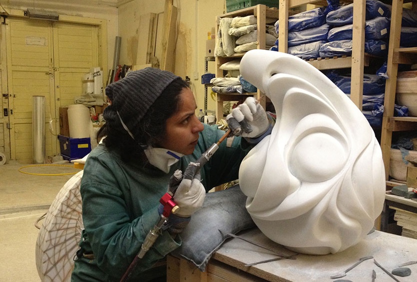 Halima chiselling a sculpture