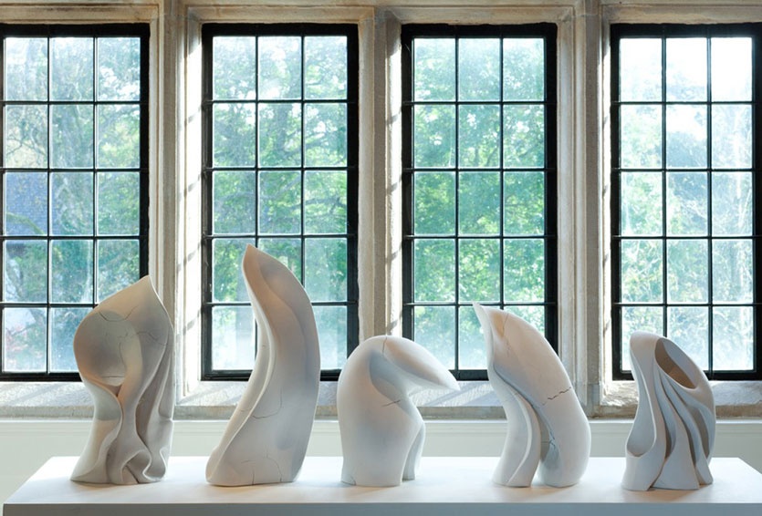 five sculptures infront of bright window