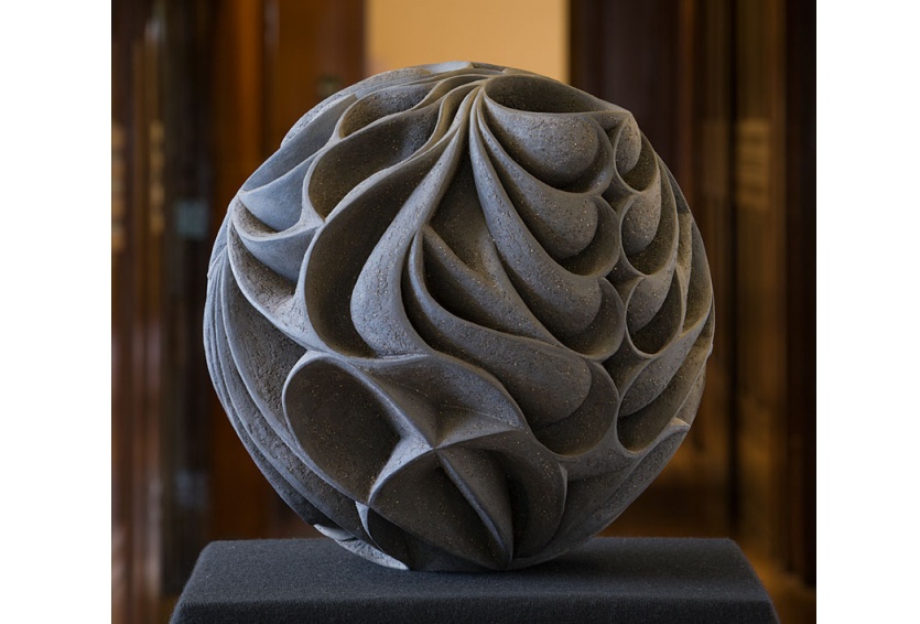 Dark almost black carved spherical sculpture
